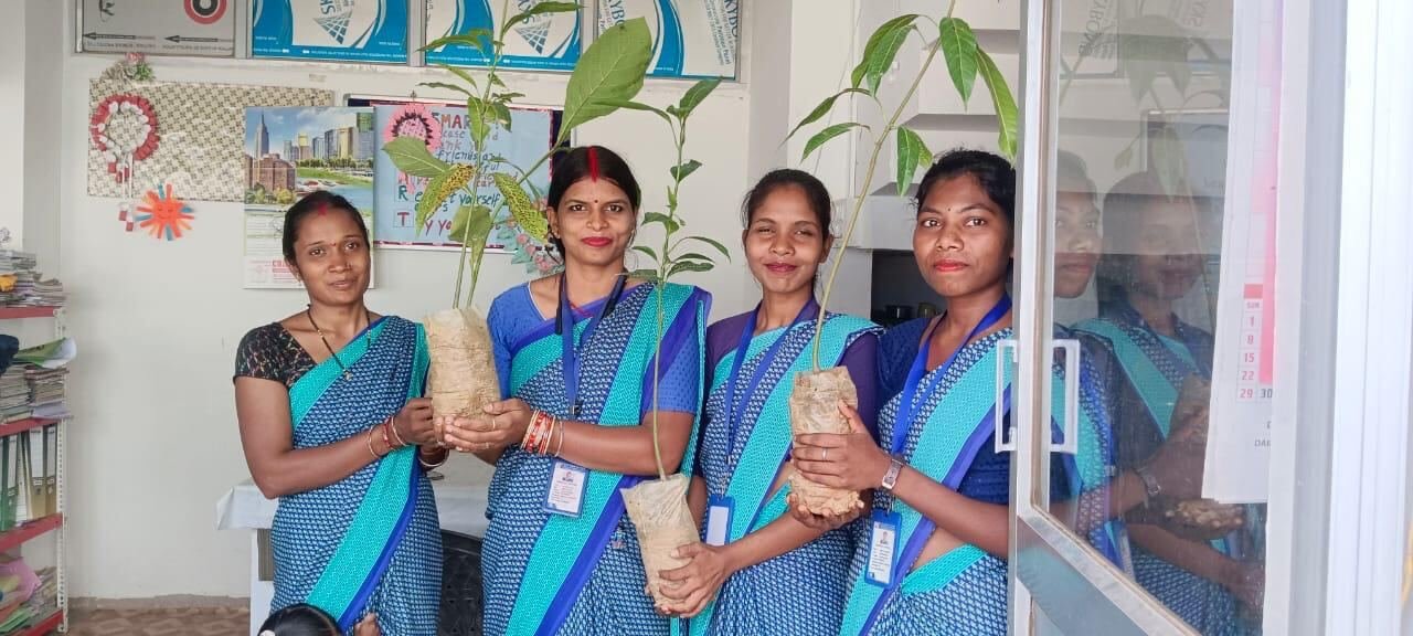 Four RGS teachers holding saplings in the school office